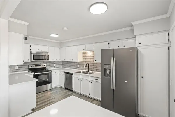 a kitchen with stainless steel appliances granite countertop a refrigerator and a stove top oven