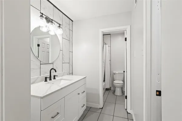 a bathroom with a double vanity sink mirror and toilet