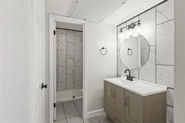 a bathroom with a double vanity sink mirror and shower