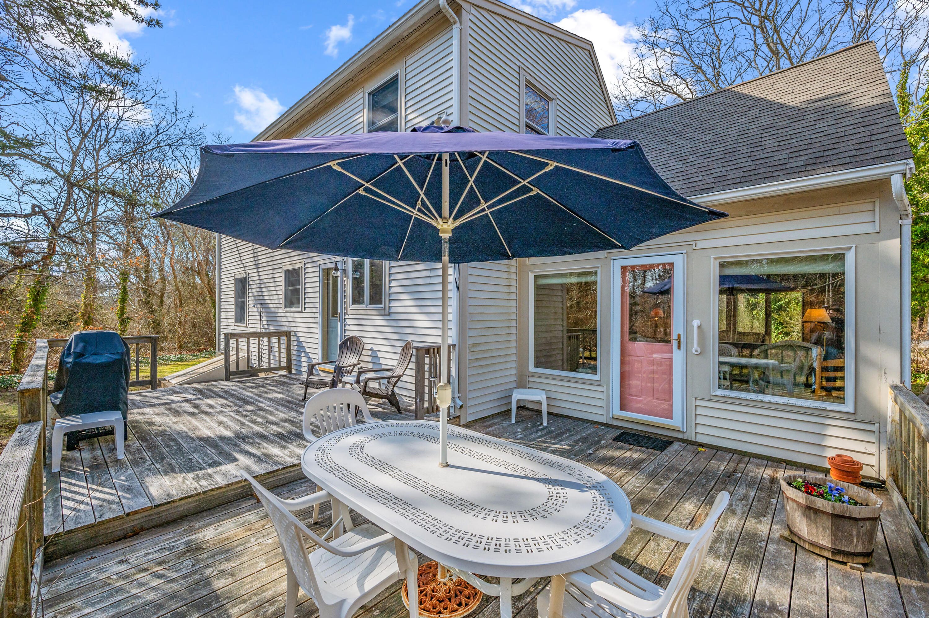 55 Bow Road Eastham, MA 02642 - Photo 39 of 44 a patio with a table and chairs under an umbrella