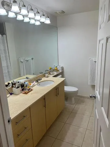 a bathroom with a sink a toilet and a mirror