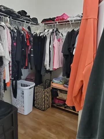 a view of walk in closet with clothes and shoes