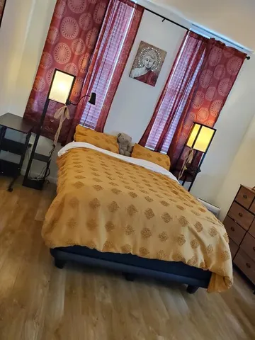 a bed sitting in a bedroom next to a lamp