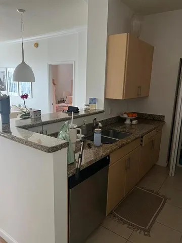 a kitchen with granite countertop a sink a stove and cabinets