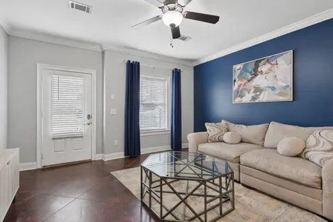 a living room with furniture and a ceiling fan