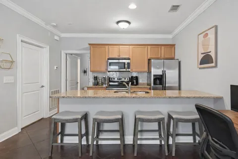 a kitchen with granite countertop a table chairs microwave and cabinets