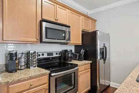 a kitchen with granite countertop a stove microwave and refrigerator