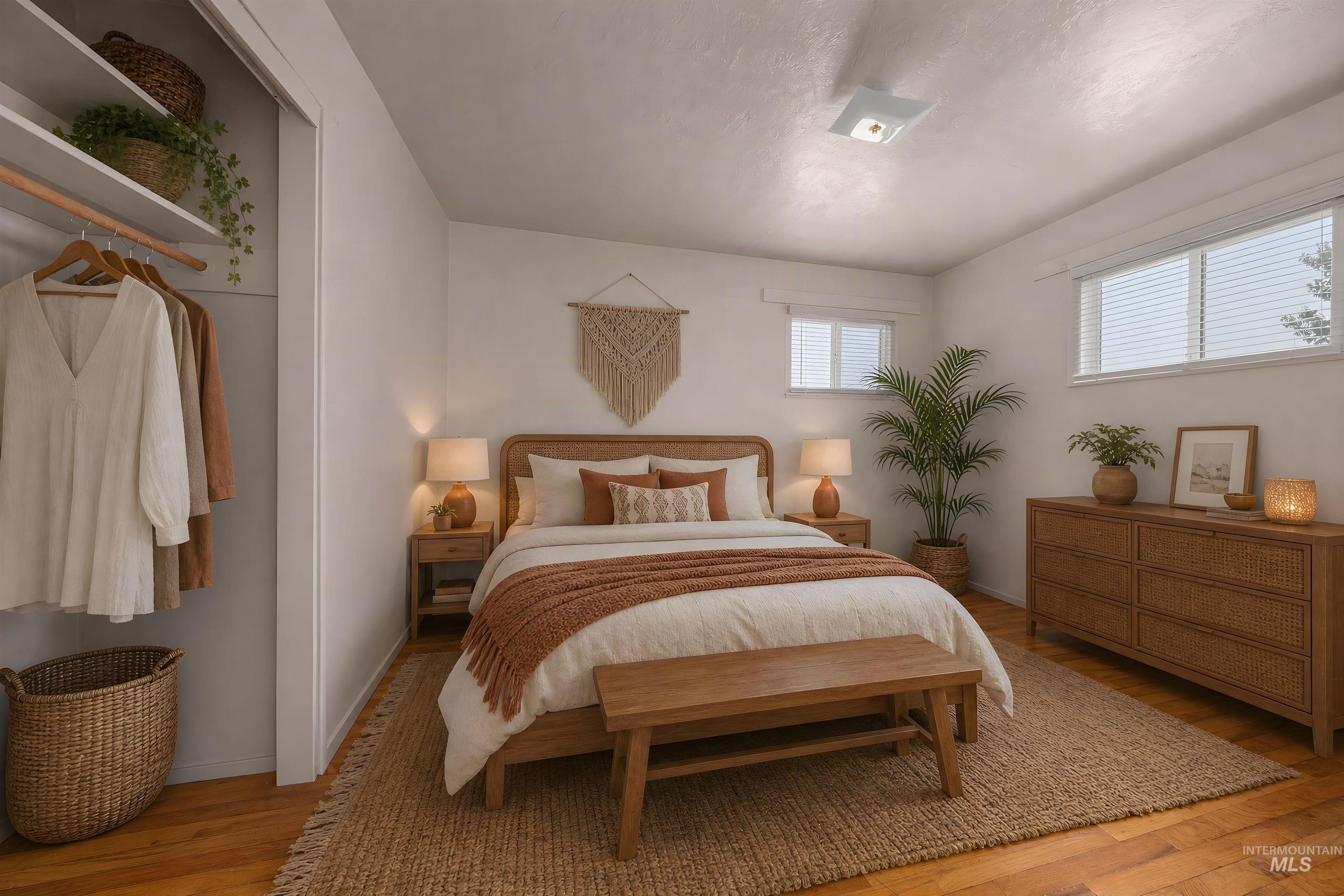1741 Cove Road Weiser, ID 83672 - Photo 22 of 46 Bedroom featuring wood-finish flooring, two window units with blinds, and a built-in closet with shelving and a hanging rod