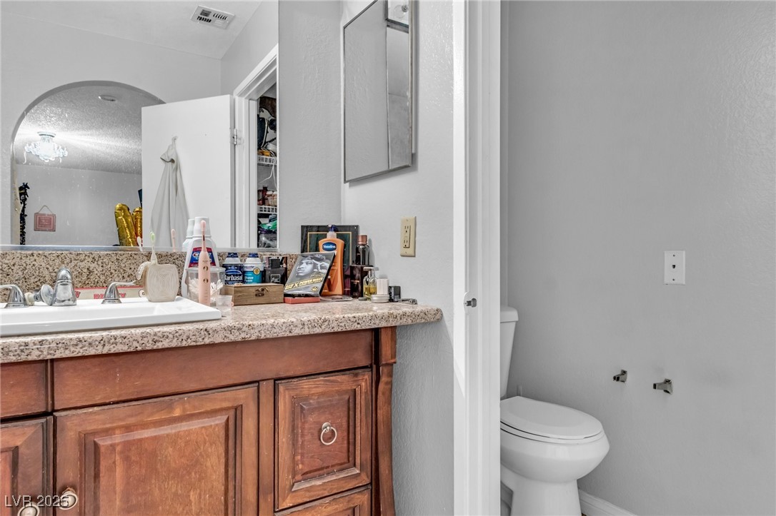 2200 South Fort Apache Road, Unit 1007 Las Vegas, NV 89117 - Photo 17 of 30 Bathroom with visible vents, vanity, toilet, and a textured ceiling