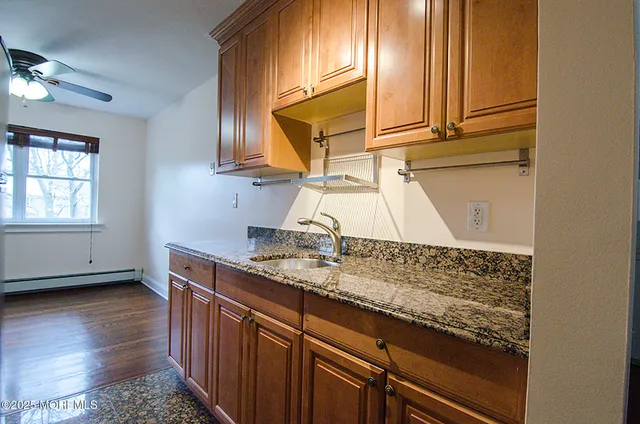a kitchen with granite countertop a sink a stove and cabinets