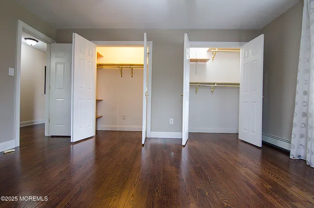 a view of empty room with wooden floor and closet