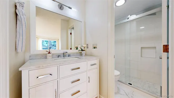 a bathroom with a granite countertop sink mirror and shower