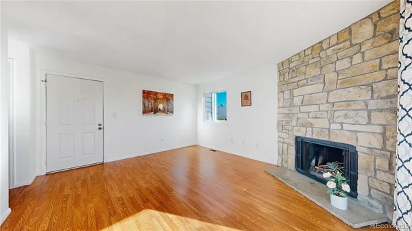 a view of empty room with wooden floor and fireplace