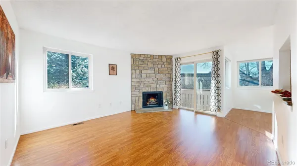 a view of a big room with wooden floor fireplace and windows