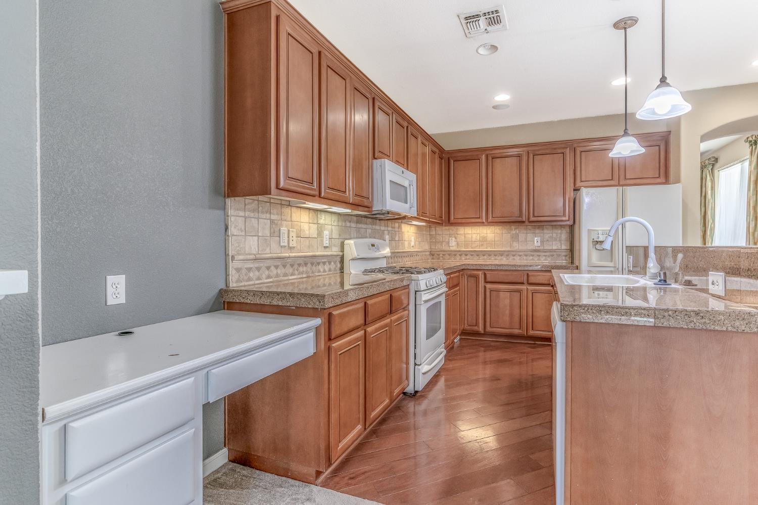 188 Thomsen Road Lathrop, CA 95330 - Photo 14 of 27 a kitchen with kitchen island granite countertop a sink stainless steel appliances and cabinets