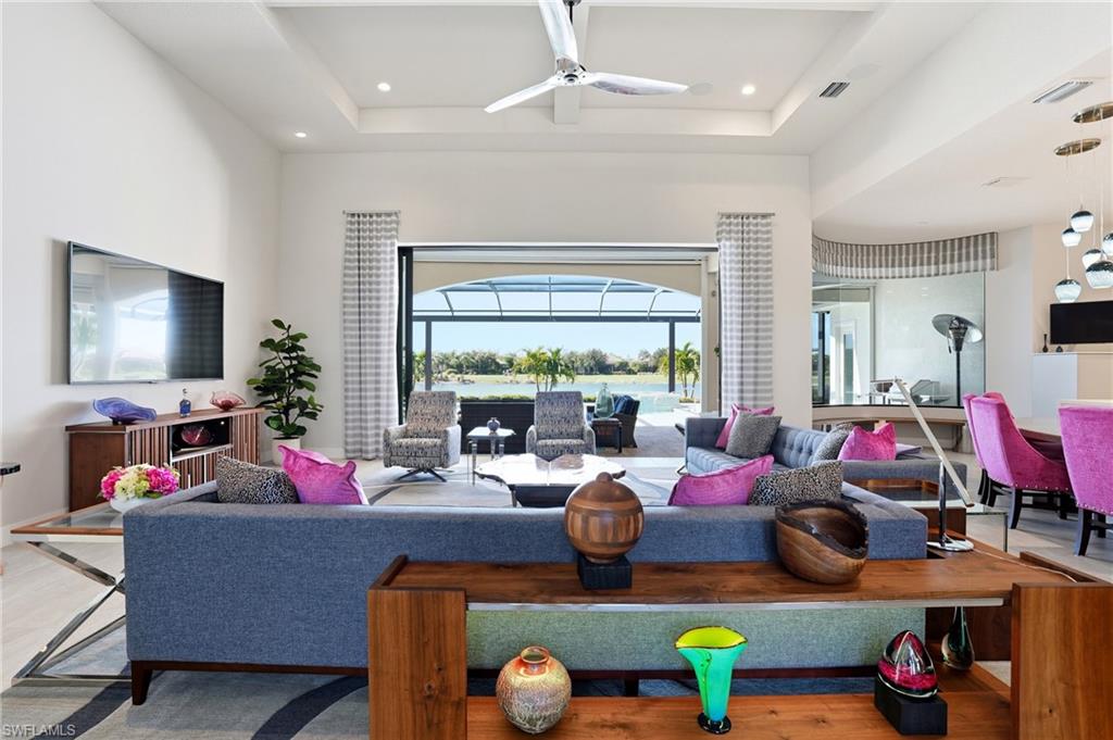 9177 Esplanade Boulevard Naples, FL 34119 - Photo 14 of 50 Living room featuring a ceiling fan, a high ceiling, a tray ceiling, and recessed lighting