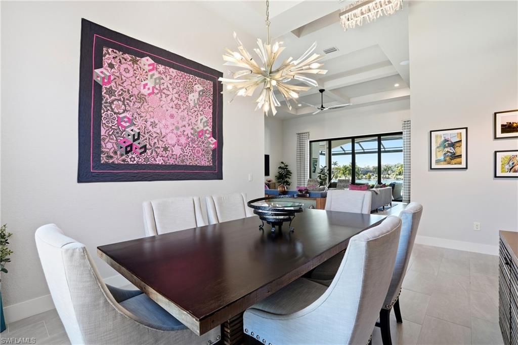 9177 Esplanade Boulevard Naples, FL 34119 - Photo 20 of 50 Dining space featuring beamed ceiling, a ceiling fan, coffered ceiling, and a chandelier