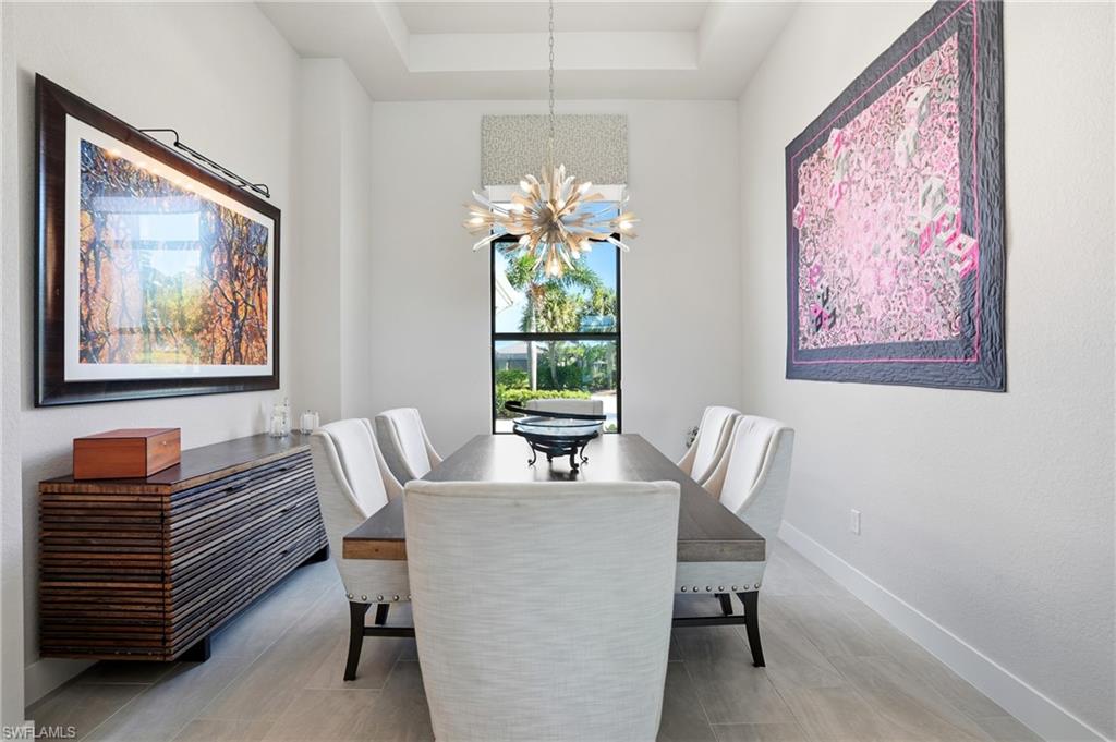 9177 Esplanade Boulevard Naples, FL 34119 - Photo 21 of 50 Dining room with a chandelier and a tray ceiling