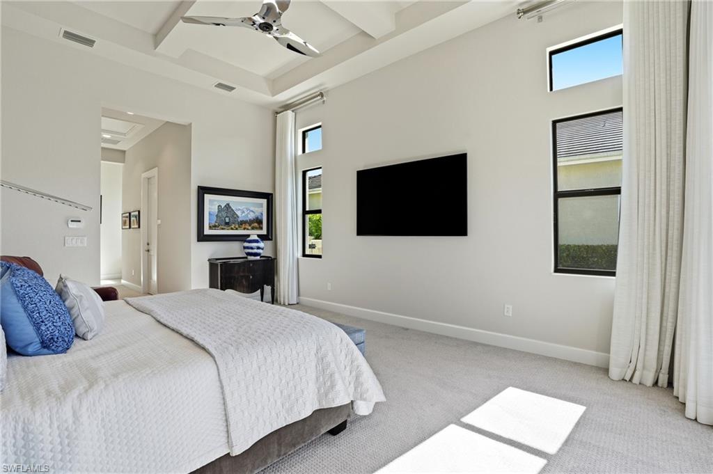 9177 Esplanade Boulevard Naples, FL 34119 - Photo 24 of 50 Bedroom featuring beamed ceiling, carpet flooring, multiple windows, coffered ceiling, and a ceiling fan
