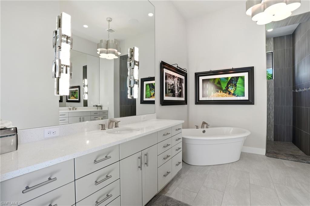 9177 Esplanade Boulevard Naples, FL 34119 - Photo 25 of 50 Bathroom featuring vanity, walk in shower, a freestanding tub, light tile patterned floors, and recessed lighting