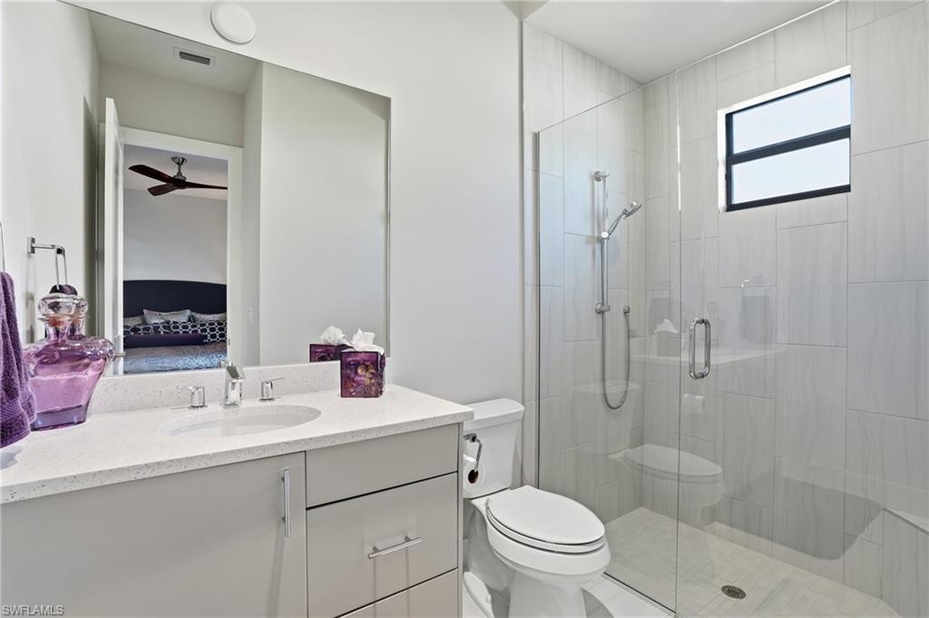 9177 Esplanade Boulevard Naples, FL 34119 - Photo 28 of 50 Bathroom featuring ensuite bathroom, vanity, a shower stall, and ceiling fan