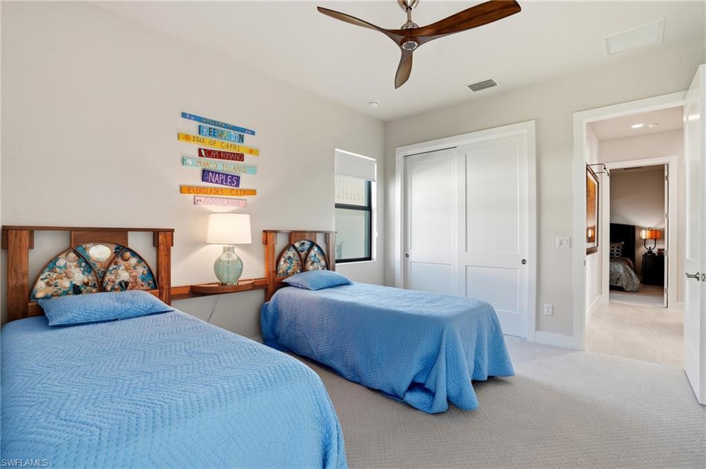 9177 Esplanade Boulevard Naples, FL 34119 - Photo 29 of 50 Bedroom featuring ceiling fan, carpet flooring, and a closet
