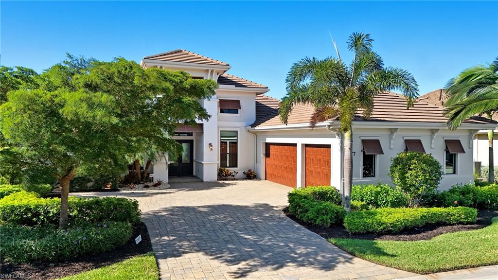 9177 Esplanade Boulevard Naples, FL 34119 - Photo 48 of 50 View of front of house with decorative driveway, stucco siding, and an attached garage
