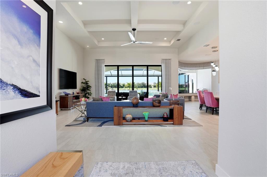 9177 Esplanade Boulevard Naples, FL 34119 - Photo 9 of 50 Living area featuring beamed ceiling, coffered ceiling, a ceiling fan, a high ceiling, and recessed lighting