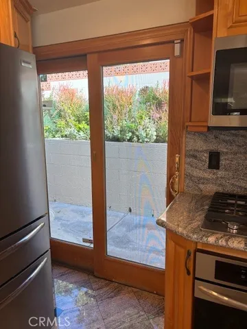 a kitchen with a stove and a wooden floor