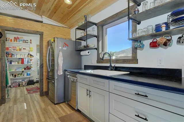a kitchen with stainless steel appliances granite countertop a refrigerator and a sink