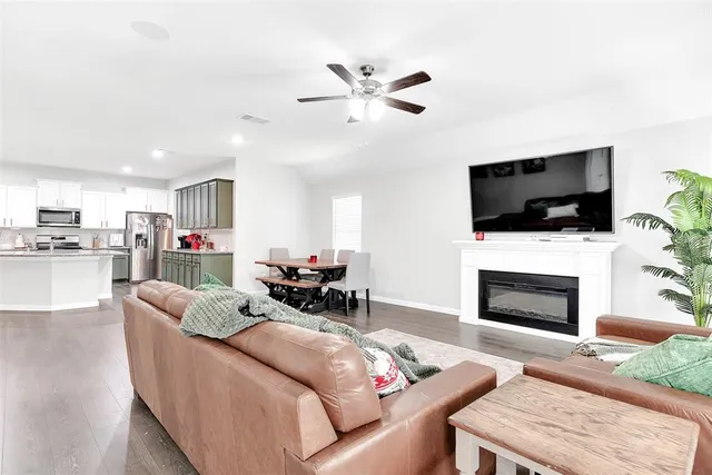 a living room with furniture a fireplace and a flat screen tv