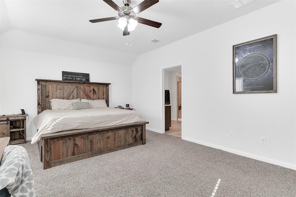 707 Range Drive Princeton, TX 75407 - Photo 14 of 29 a bedroom with a large bed and a chandelier