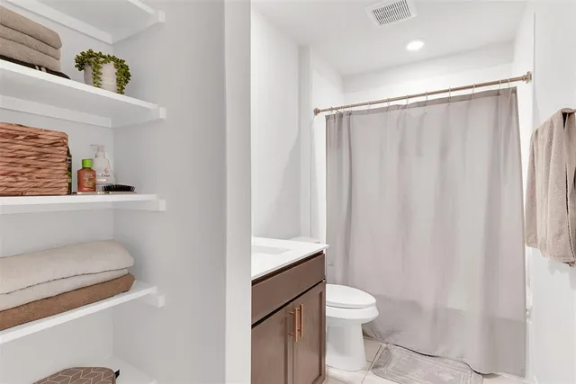 a bathroom with a granite countertop toilet a sink and a shower