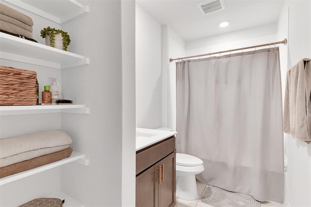 707 Range Drive Princeton, TX 75407 - Photo 17 of 29 a bathroom with a granite countertop toilet a sink and a shower
