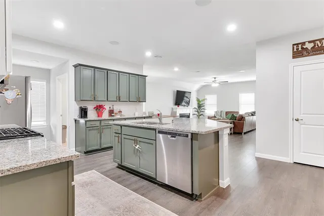 a kitchen with stainless steel appliances granite countertop a sink stove and cabinets