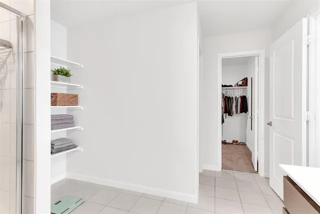 a view of a hallway with closet and a window
