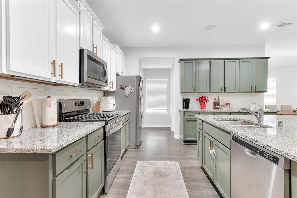 707 Range Drive Princeton, TX 75407 - Photo 3 of 29 a kitchen with stainless steel appliances granite countertop a sink stove refrigerator and cabinets