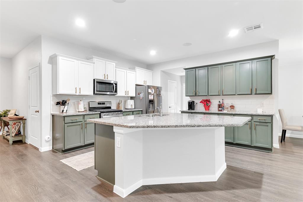 707 Range Drive Princeton, TX 75407 - Photo 4 of 29 a kitchen with granite countertop a sink cabinets and stainless steel appliances
