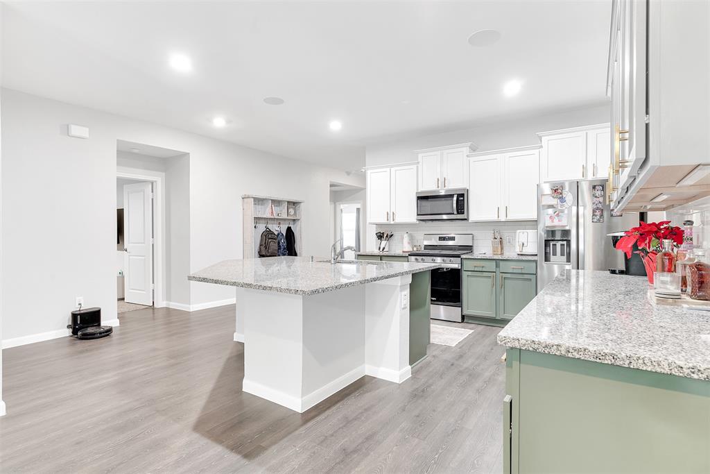707 Range Drive Princeton, TX 75407 - Photo 5 of 29 a kitchen with stainless steel appliances granite countertop a sink dishwasher a refrigerator and a stove with wooden floors