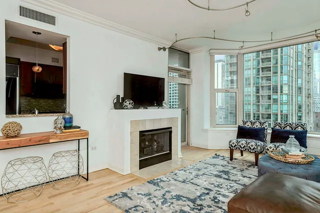 a living room with furniture a flat screen tv and a fireplace