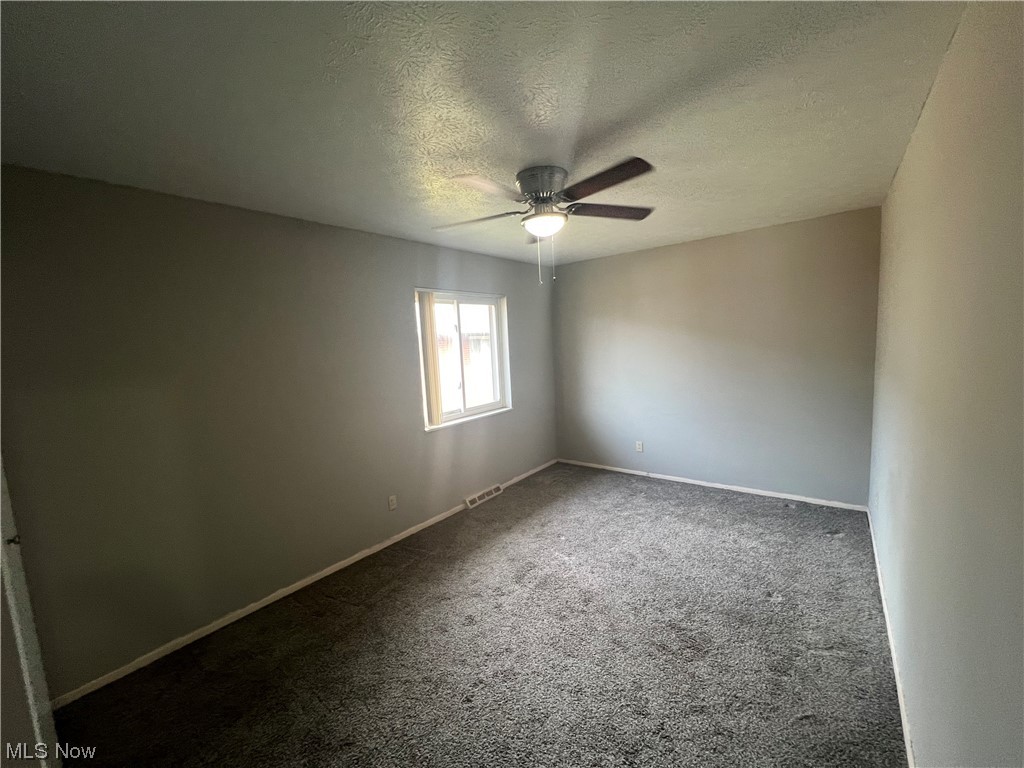 5651 Broadview Road, Unit C 07 Cleveland, OH 44134 - Photo 15 of 15 Spare room with dark colored carpet, a textured ceiling, and ceiling fan