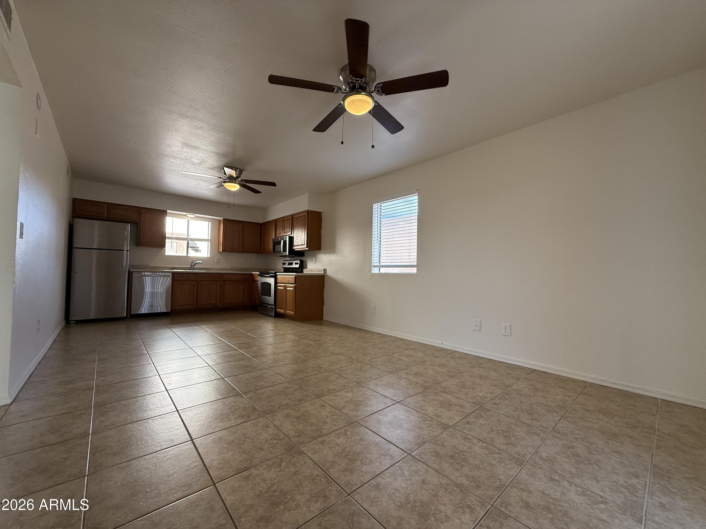 2650 East McKellips Road, Unit 105 Mesa, AZ 85213 - Photo 4 of 13 a view of empty room with kitchen and window