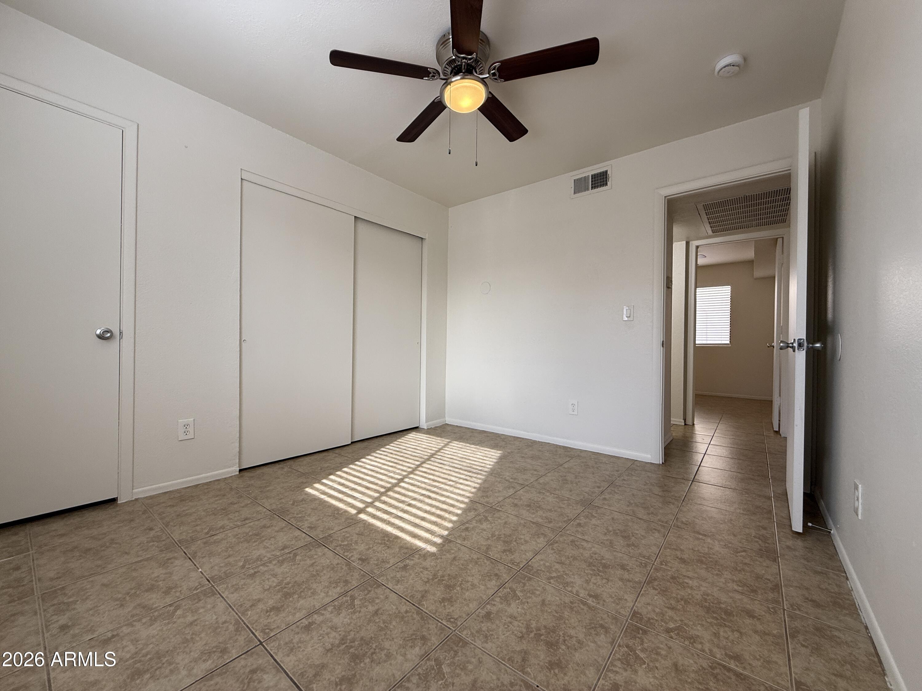 2650 East McKellips Road, Unit 105 Mesa, AZ 85213 - Photo 10 of 13 an empty room with closet and a chandelier fan