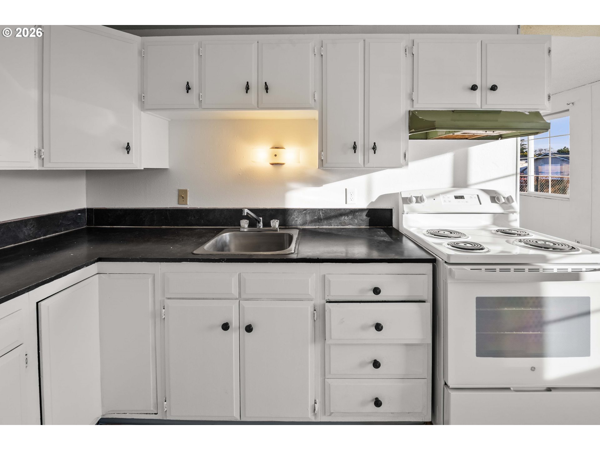 2440 Pine Street Seaside, OR 97138 - Photo 7 of 22 a kitchen with granite countertop white cabinets and white appliances