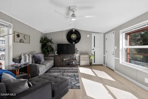 a living room with furniture a flat screen tv and a large window