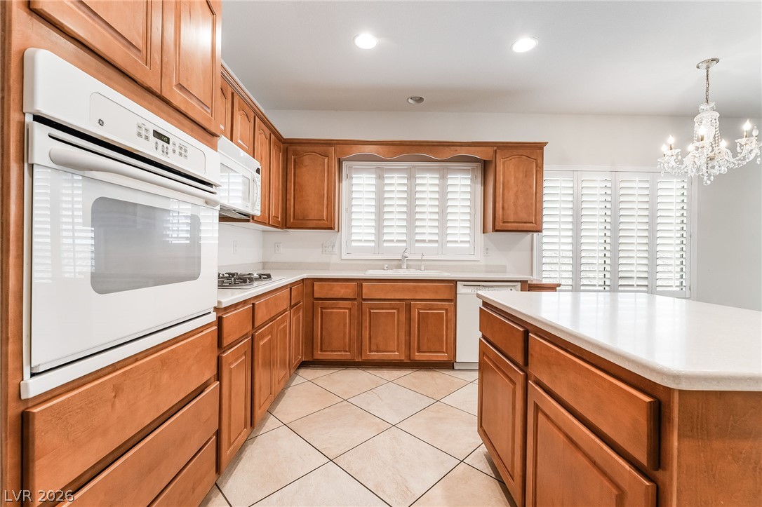 3033 Hartsville Road Henderson, NV 89052 - Photo 18 of 41 Bright, practical kitchen with warm wood cabinetry and a functional central island for culinary endeavors.