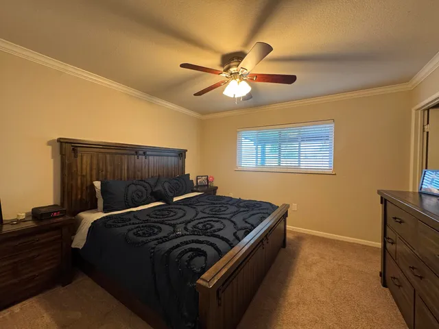 a bedroom with a bed and a flat tv screen on dresser