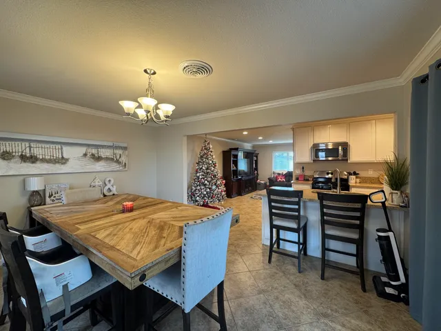 a view of a dining room with furniture and a chandelier