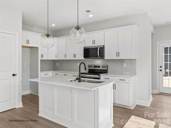 a kitchen with stainless steel appliances a stove a sink and a refrigerator