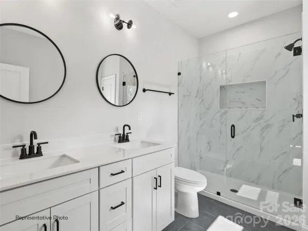 a bathroom with a double vanity sink mirror and toilet